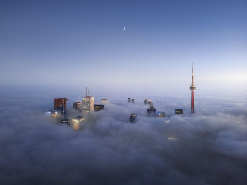 عکسی هوایی از منظرۀ مه‌گرفتۀ شهر تورنتو که فقط بلندترین ساختمان‌های شهر در آن قابل رویت هستند