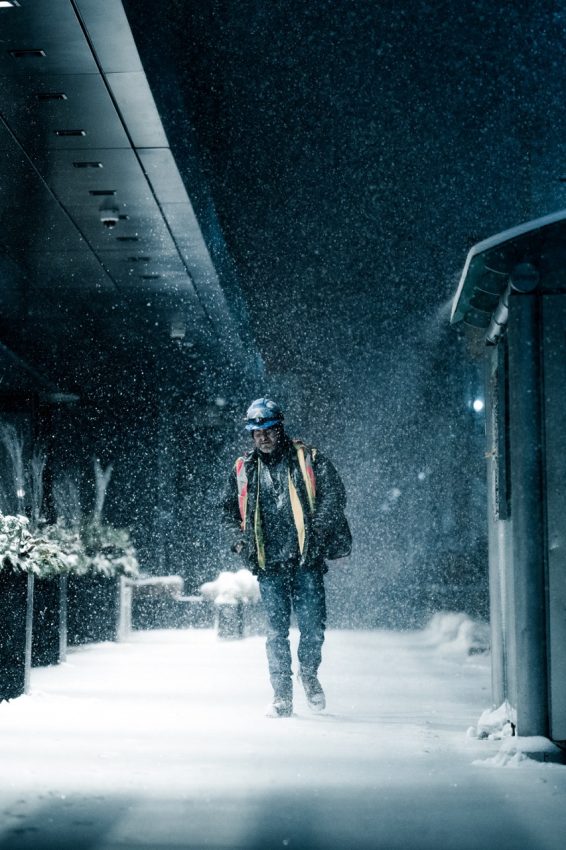 یک کارگر ساختمانی در یک صبح اواسط زمستان در تورنتو از میان برف می‌گذرد.