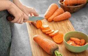 woman cutting up carrotsخوراکی‌های حاوی بتاکاروتن